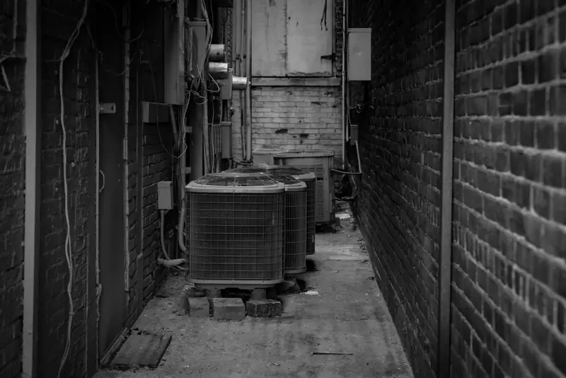 Outdoor AC units lined up in a narrow alley